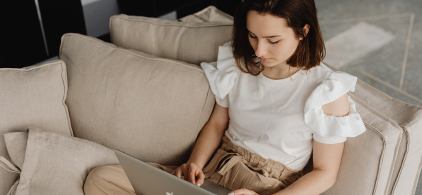 Frau mit Laptop auf dem Sofa zur Medikamentenvorbestellung
